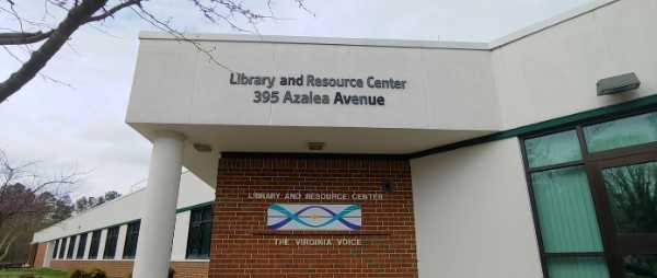 The front of the Library and Resource Center is pictured. It is a brick building with a white stucco roof.