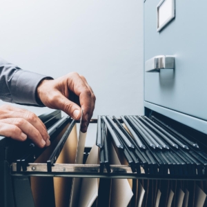 Picture of a person taking a file folder out of a filing cabinet