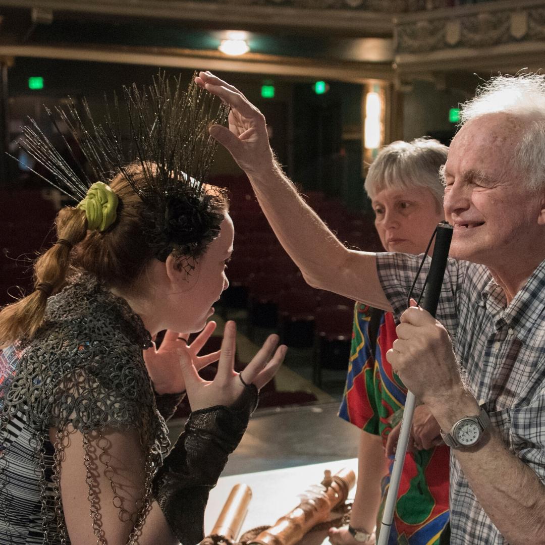 Live Audio Describer touching an actor during the tactile tour