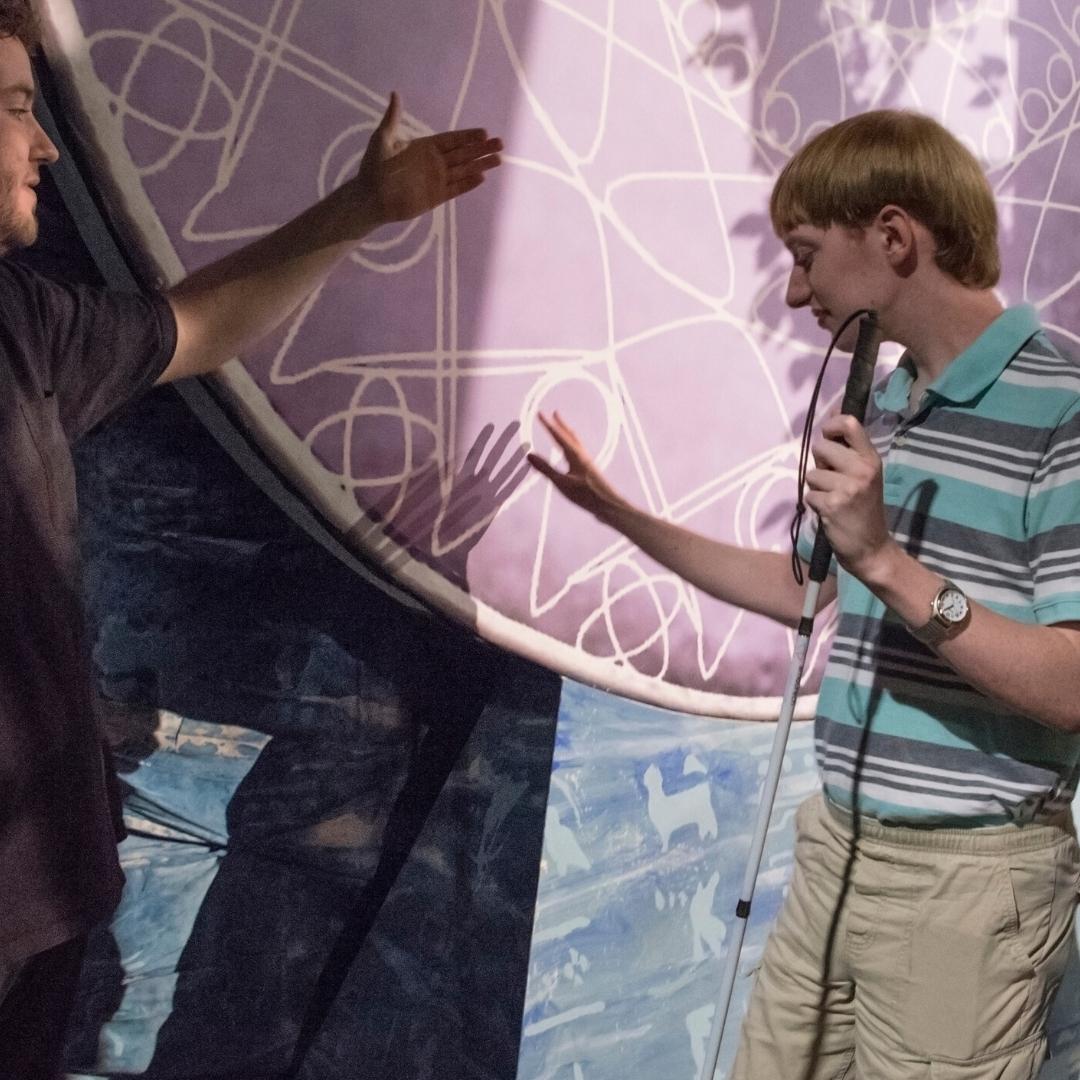 Live Audio Describer attendee touching the scenery during the tactile tour