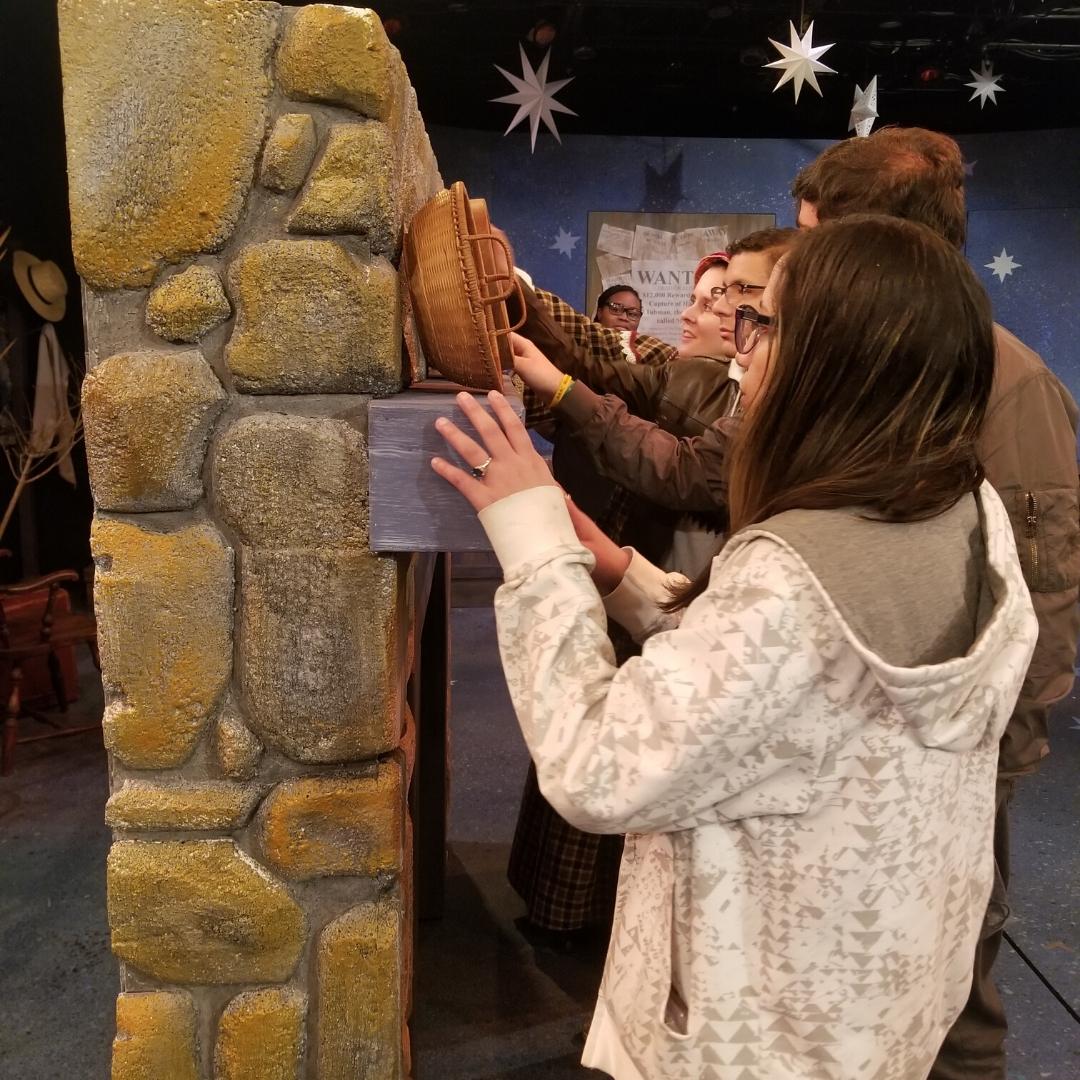 Live Audio Describer attendee touching the scenery during the tactile tour